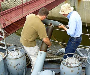 Eric and a vounteer work on a depth charge launcher